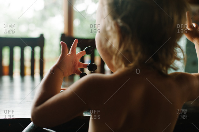 Toddler with olives on fingertips