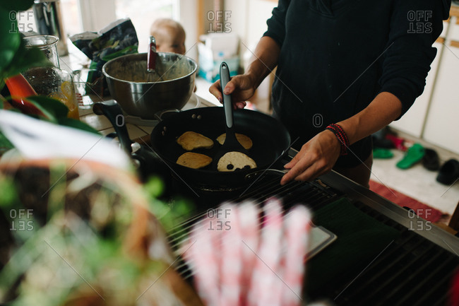 Woman making pancakes in a kitchen
