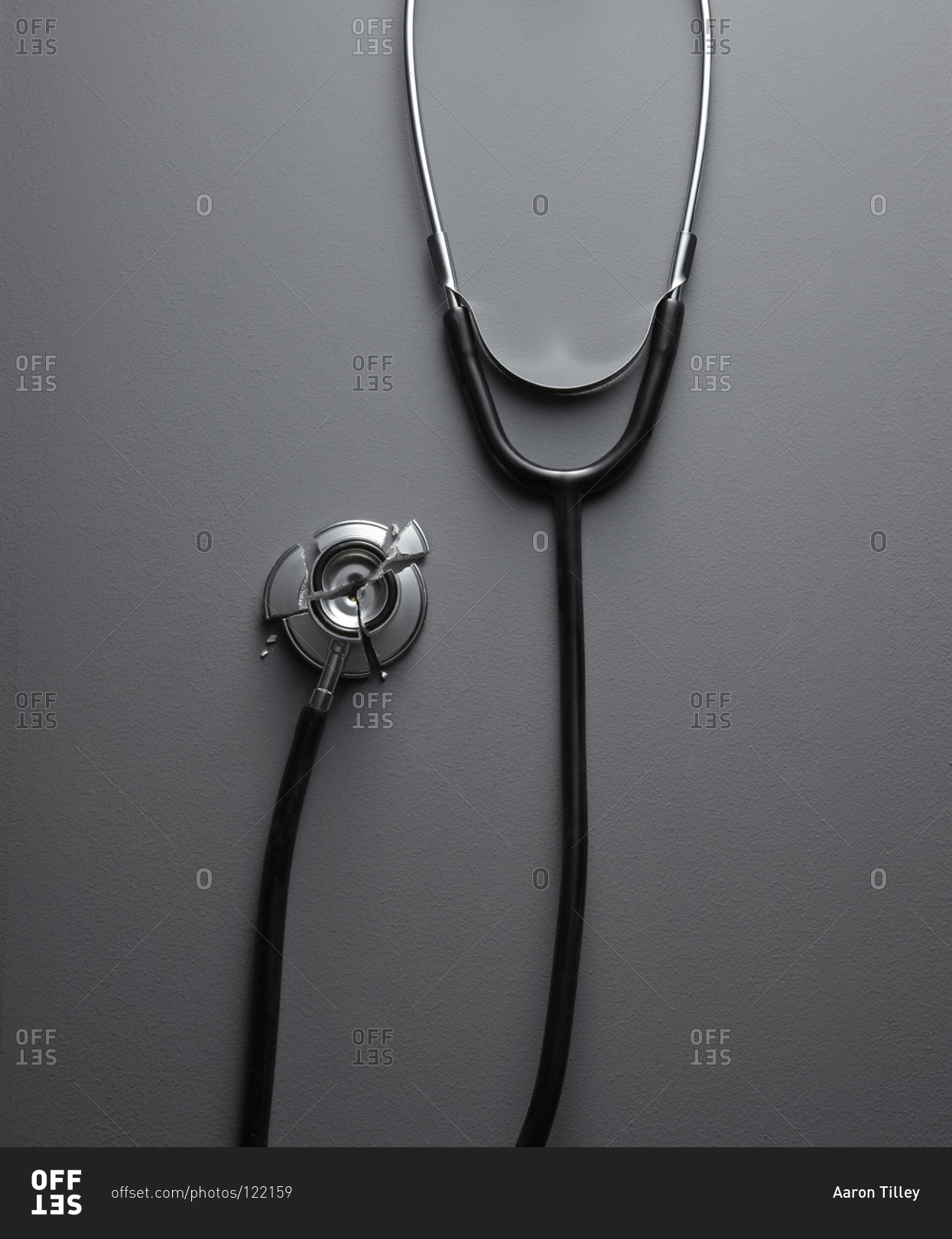 Broken stethoscope on gray surface stock photo OFFSET