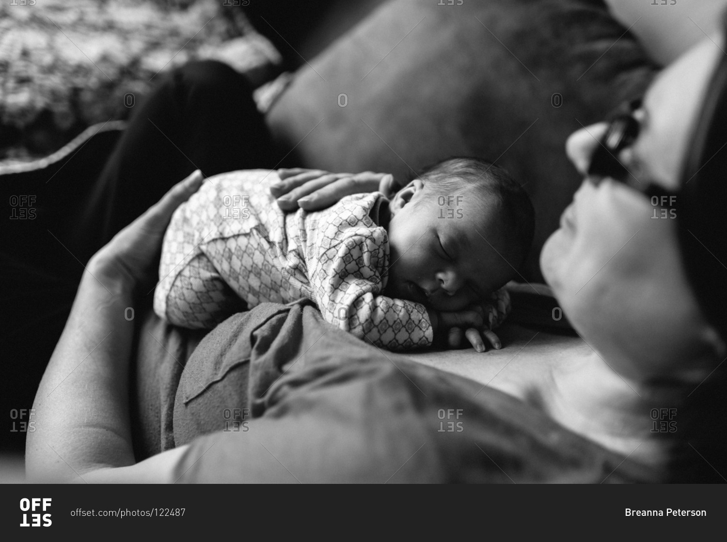 Woman holding a sleeping baby stock photo OFFSET