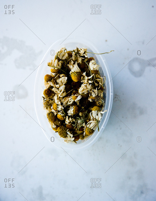 Dried chamomile in plastic container