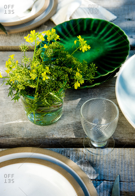 Close up of laid table with yellow wildflowers
