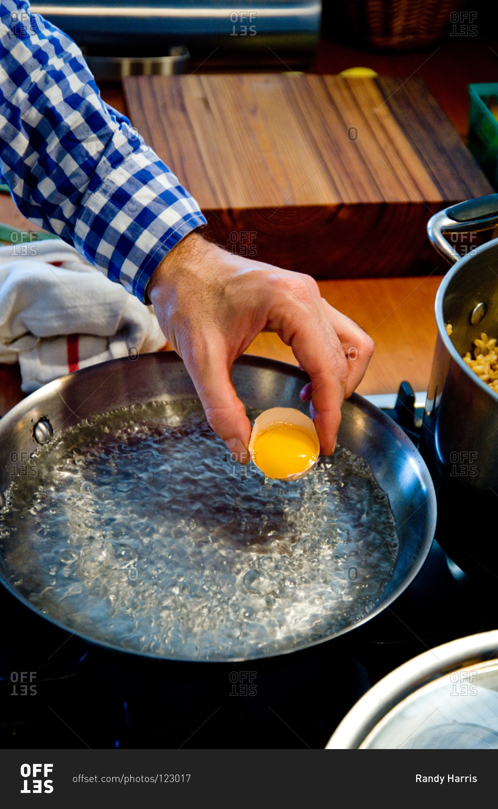 Man poaching egg in boiling water stock photo OFFSET
