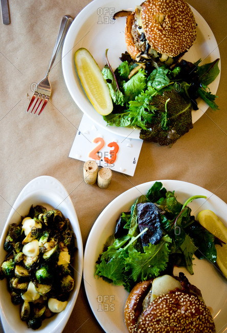 Hamburgers with salad and pickles served on a table