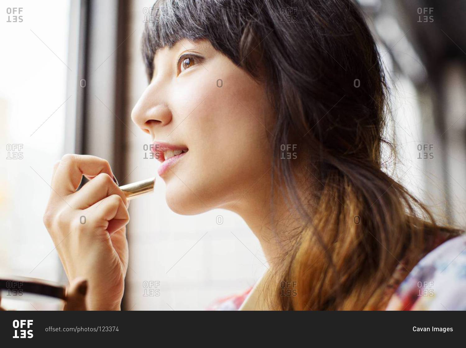 Close up of woman applying lipstick in a pub