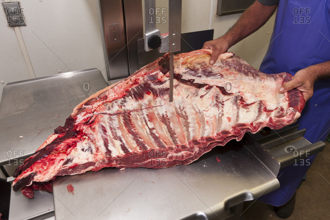 A butcher cuts a side of beef