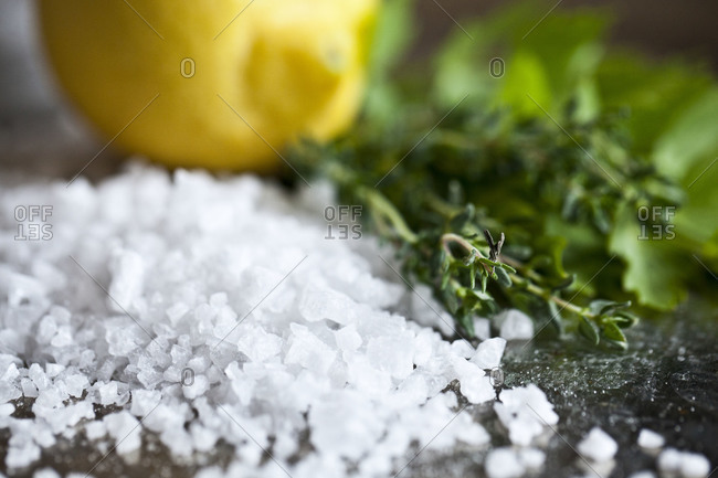 Close up of coarse sea salt with a lemon and thyme sprigs