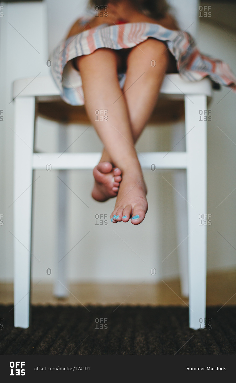 Girl dangling her feet from a chair stock photo OFFSET
