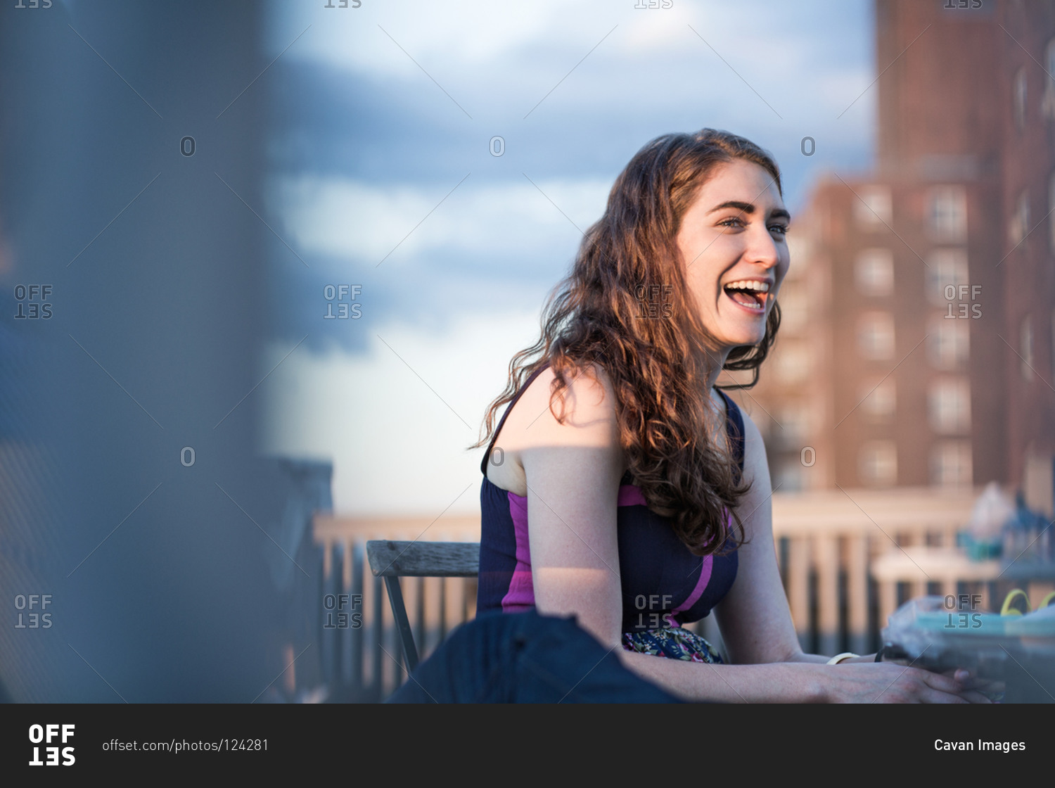 Young woman laughing at rooftop party, Brooklyn