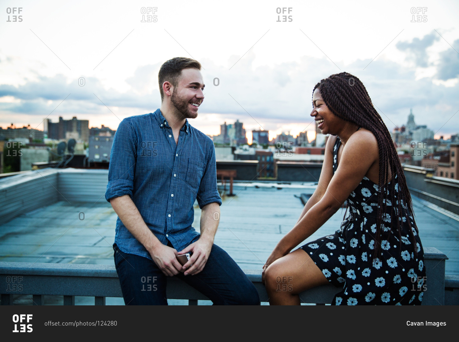 Man and woman talk and laugh at rooftop party, Brooklyn