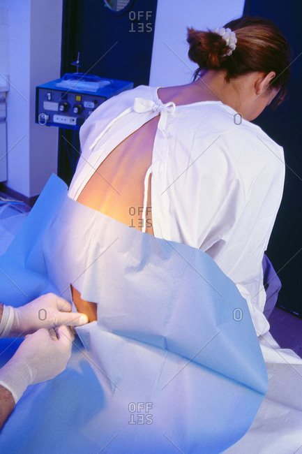 Doctor performing a Lumber Puncture procedure on a patient, also known as "Spinal Tap"