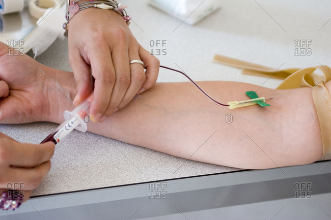 Nurse taking a blood sample during an allergology consultation.
