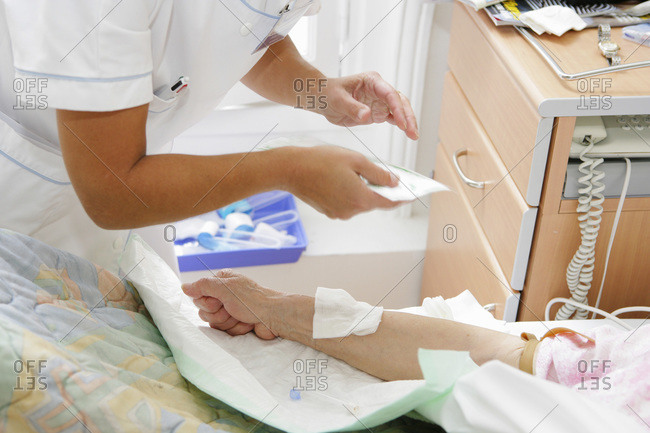 Orthopedic clinic. Nurse preparing patient for placement of a drip.