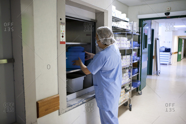 Nurse at a hospital freight elevator for sterile equipment.
