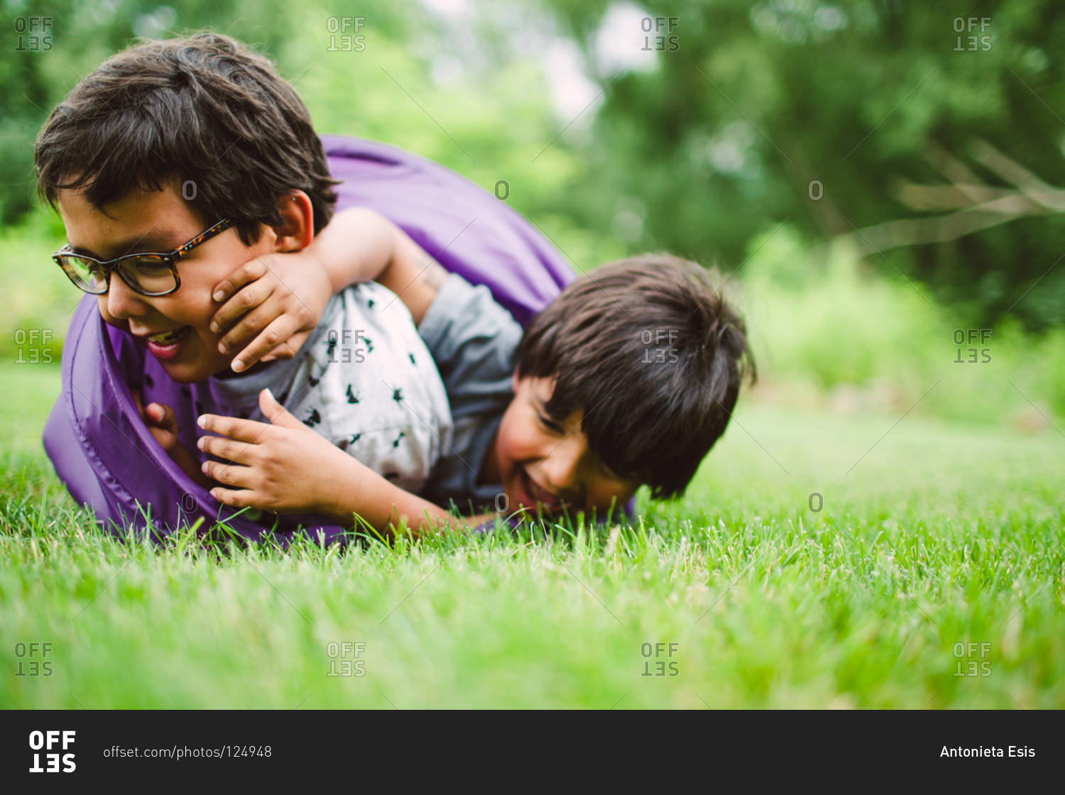 Boys wrestling in the grass