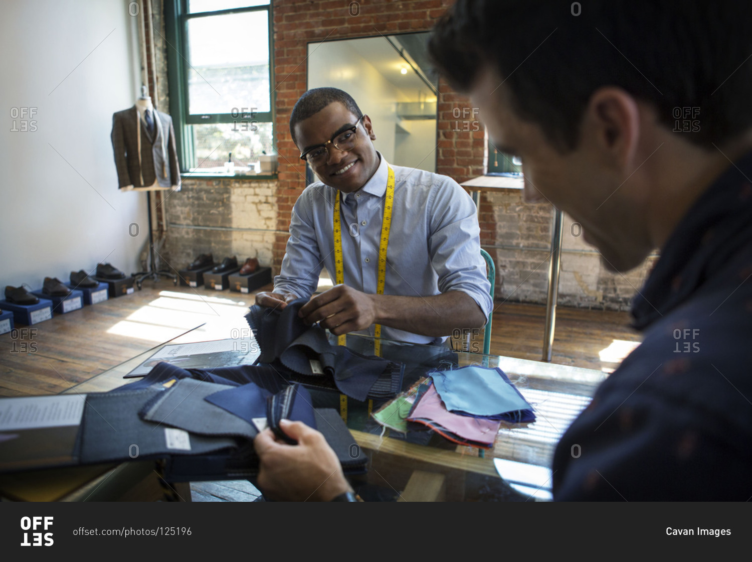 Tailor choosing fabrics with a customer