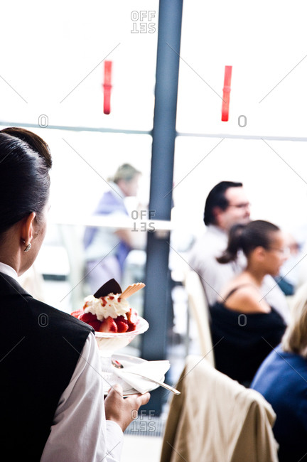 Waitress serving a strawberry dessert in a restaurant