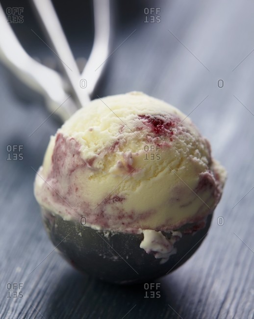 A scoop of blackberry and blueberry ice cream in an ice cream scoop