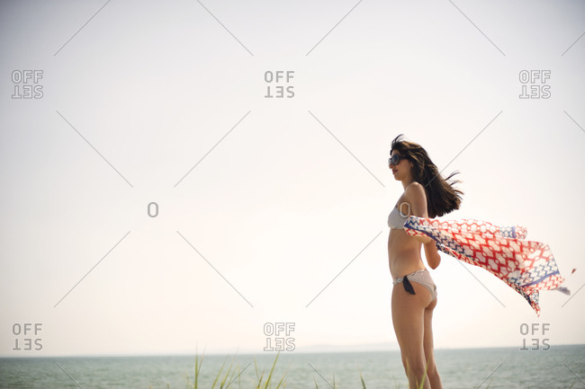 Side view of young woman standing in summer breeze