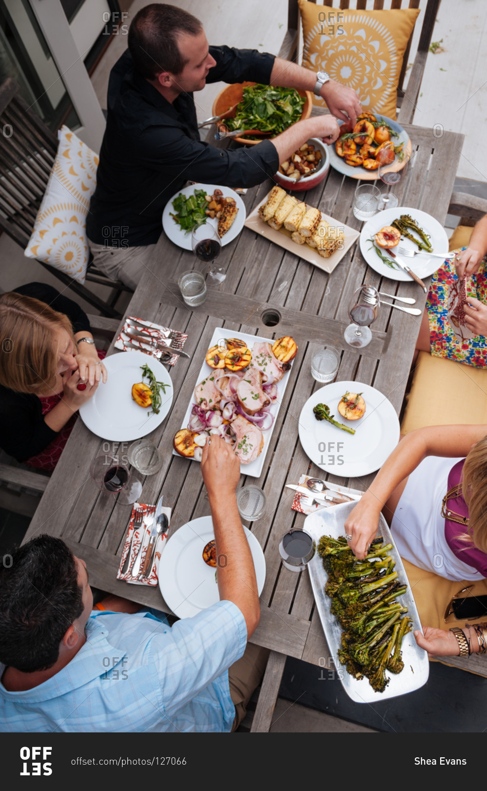 Friends enjoying a meal at a summer table on their patio prepared by a personal chef