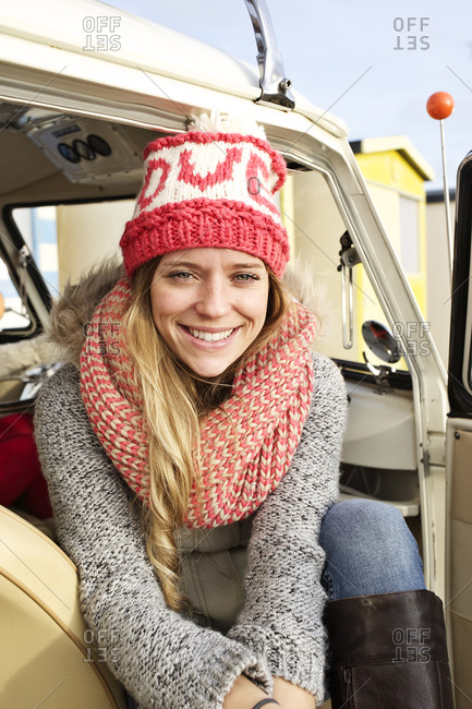 Smiling girl sitting on the front passenger seat of a camper