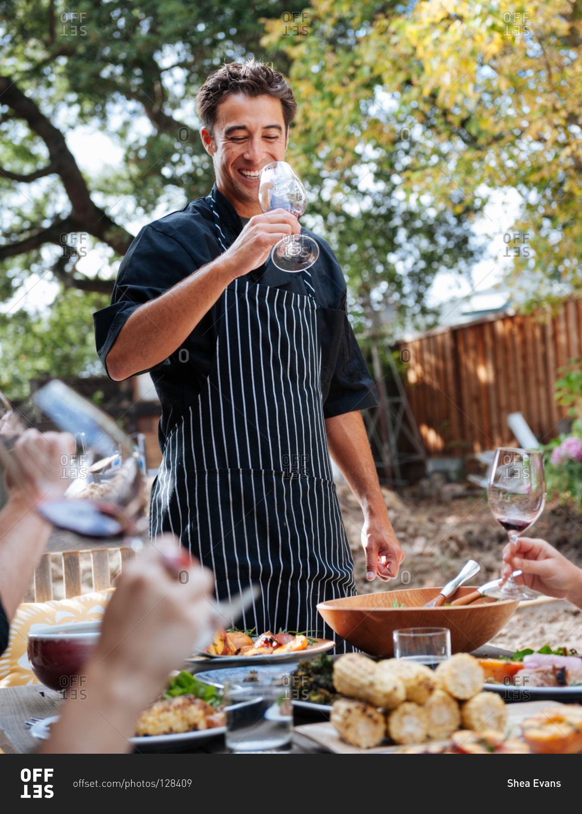 Personal chef enjoying a glass of wine with his clients at their outdoor patio with a meal