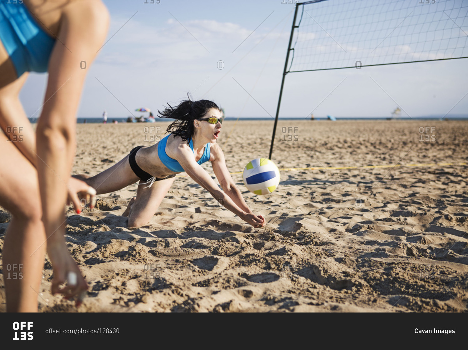 Beach volleyball player dives for a shot