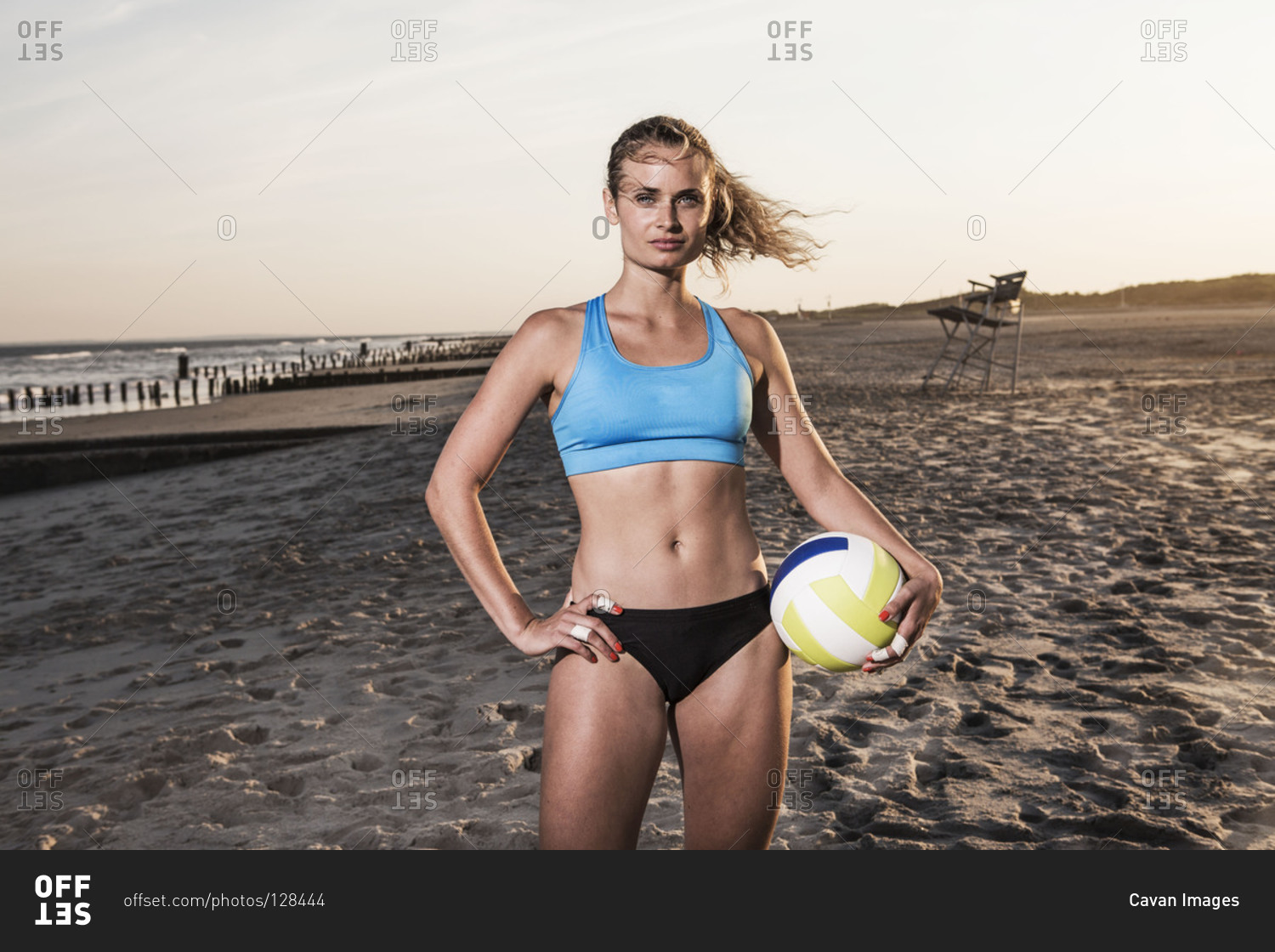 Volleyball player holding a ball on a sandy beach