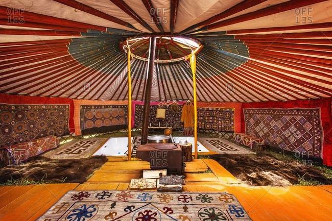 Mongolia - July 22, 2013: Interior of an yurt covered with carpets and a heater in the center
