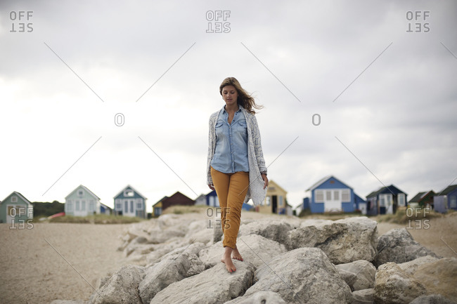 Young woman walking on rocks at a beach