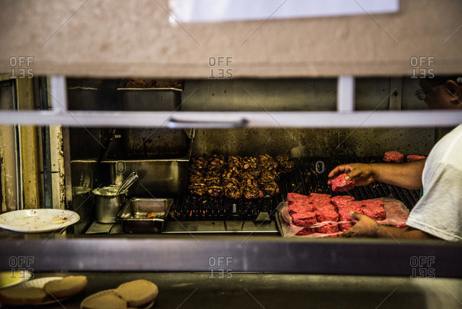 Person preparing hamburger patties in a restaurant