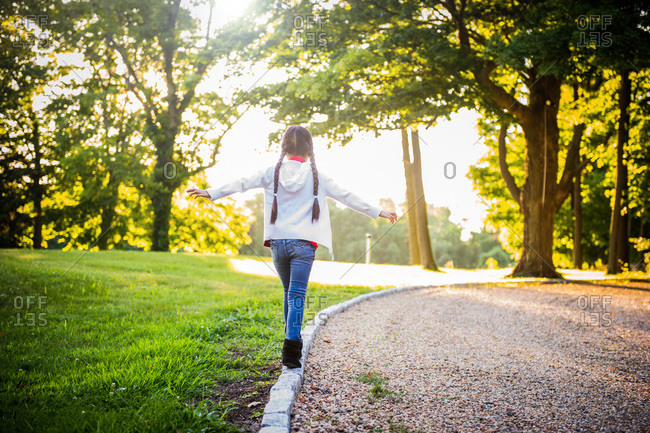 Girl walking on curb - Offset stock photo - OFFSET