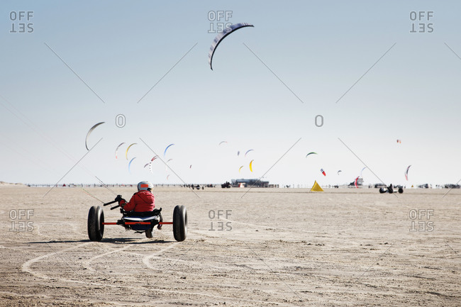 Boy riding kite buggy on beach
