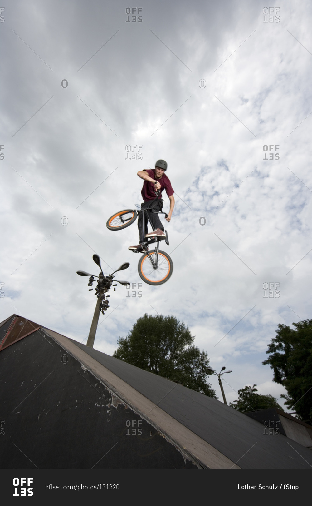 A young man in mid-air doing a stunt on a BMX bike