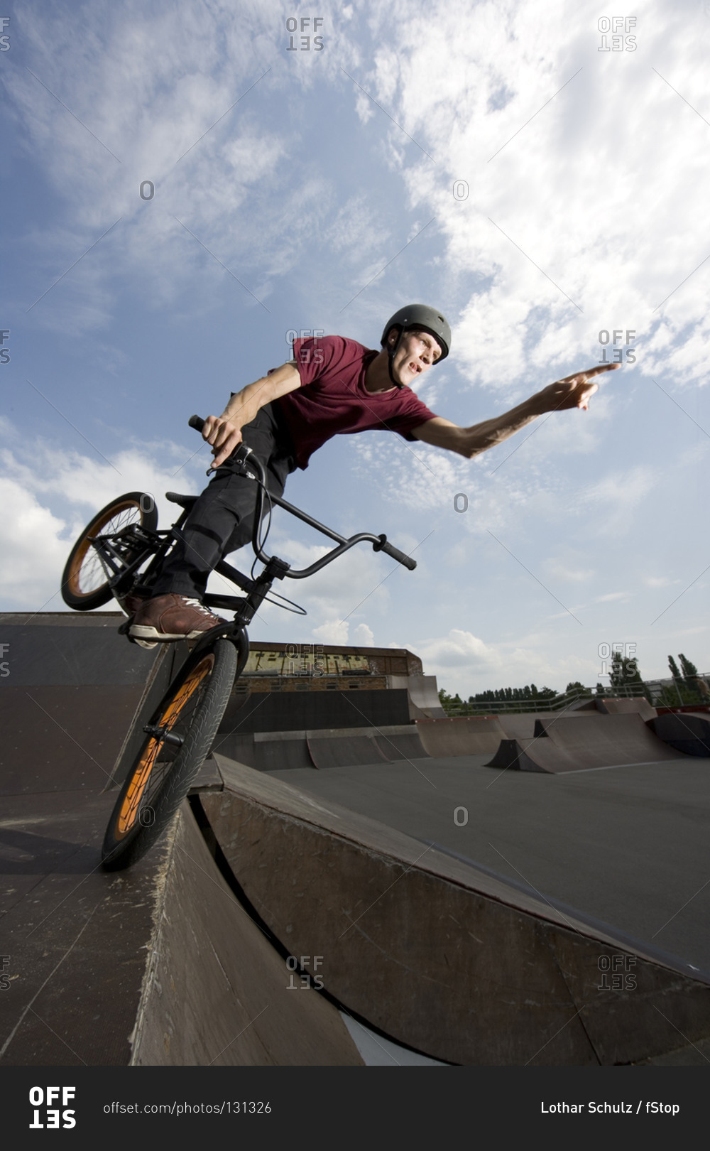 A BMX rider balancing on the edge of a sports ramp