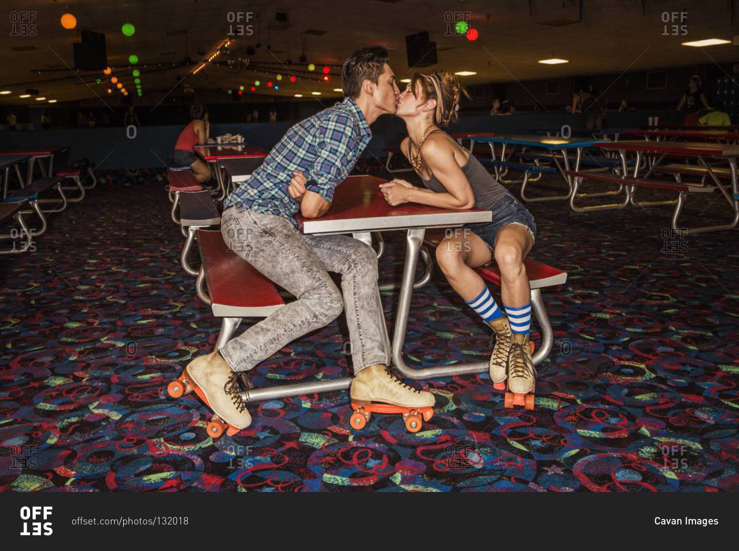 Young couple kissing at a roller skate rink