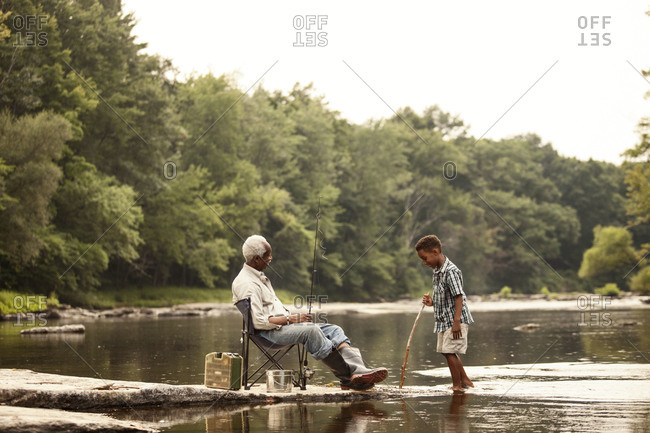 Grandson and grandfather talking on shore
