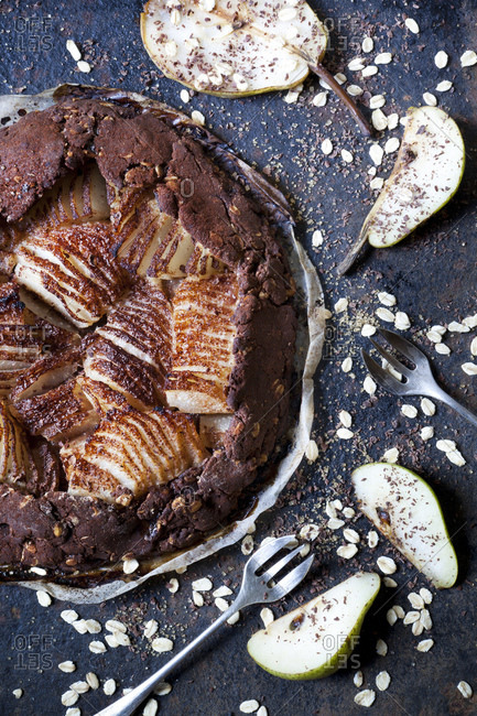 Homemade pears and dark chocolate tart on rustic blue background