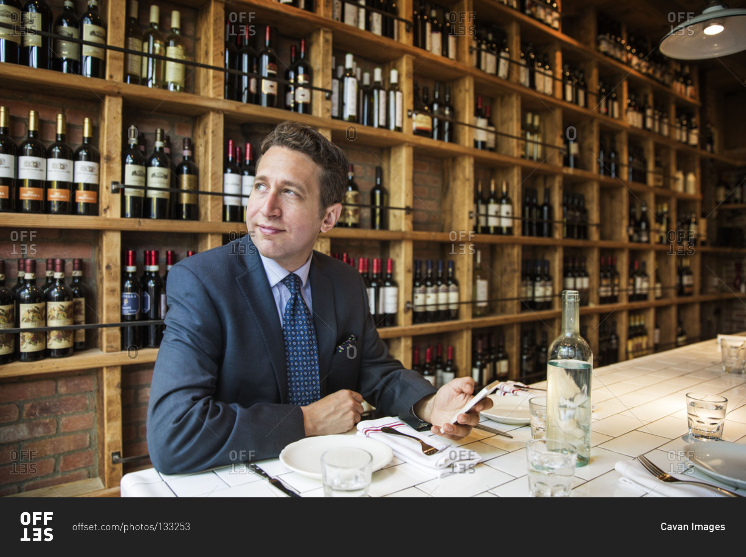 Man in suit sitting in a wine shop