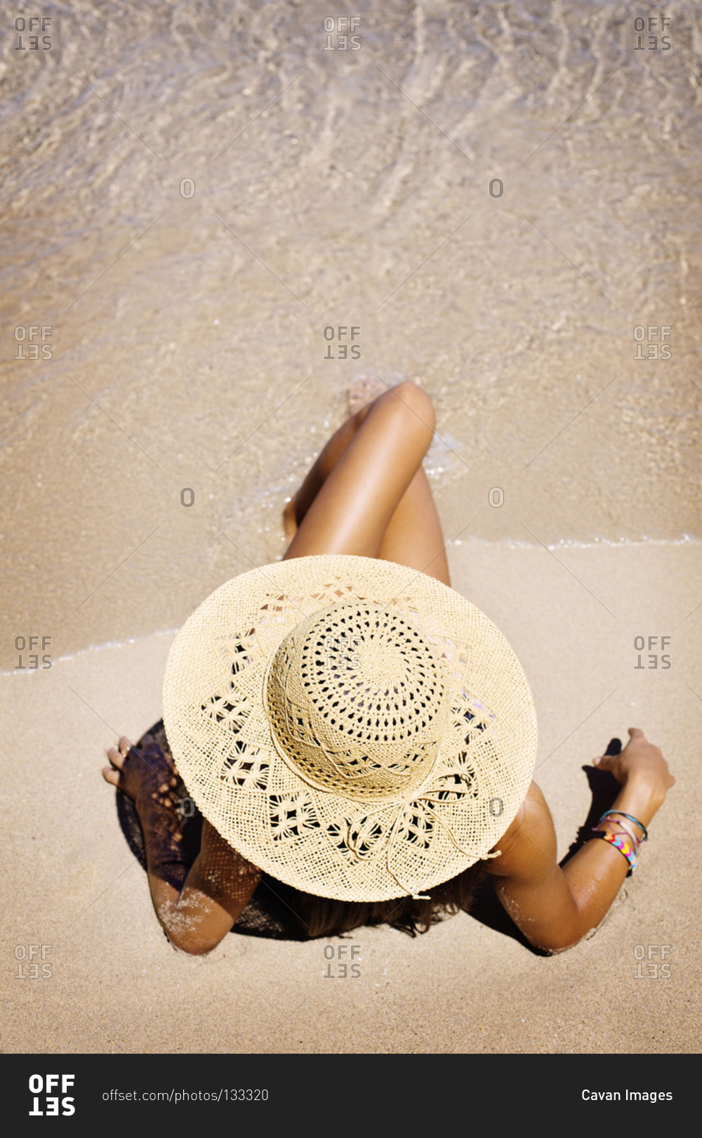 High angle view of woman sun-bathing on beach