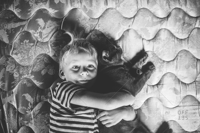 Young boy resting with a cat