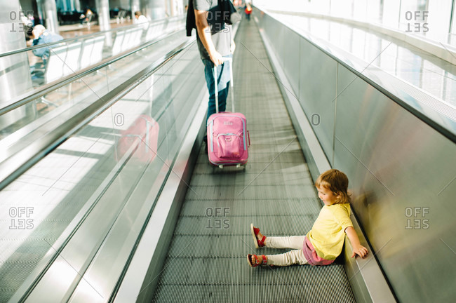 Young girl traveling by moving sidewalk