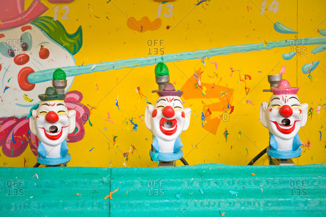 Clown head targets of a water gun game at a carnival stock photo - OFFSET