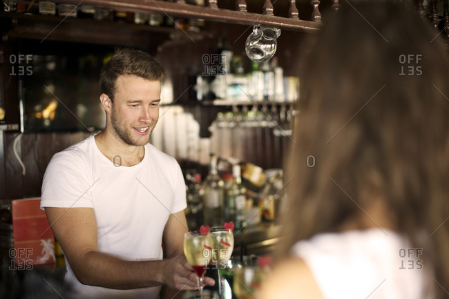 Bartender serving champagne cocktails in a bar