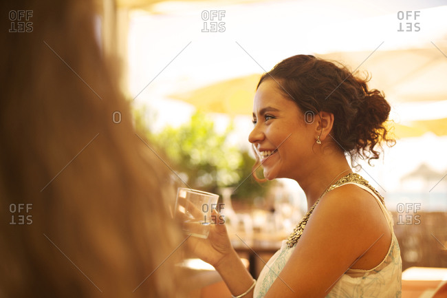 Side view of woman sitting in an outdoor restaurant