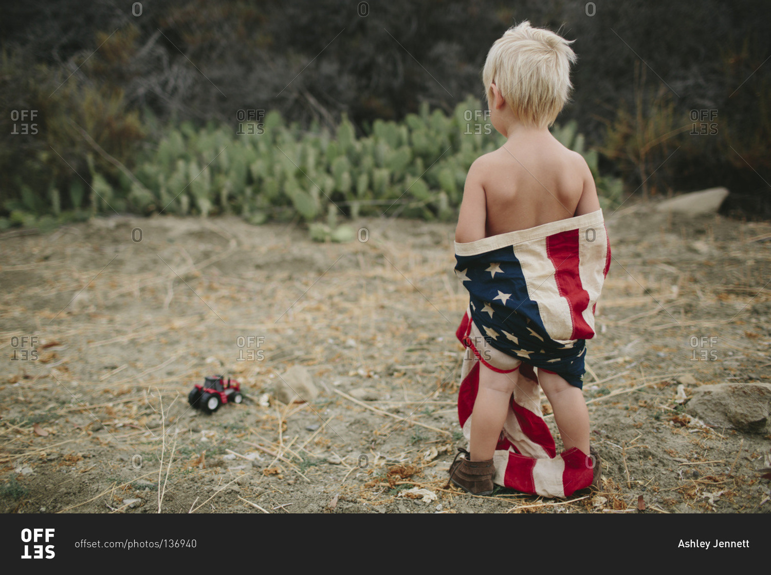 Back view of boy wrapped in an American flag