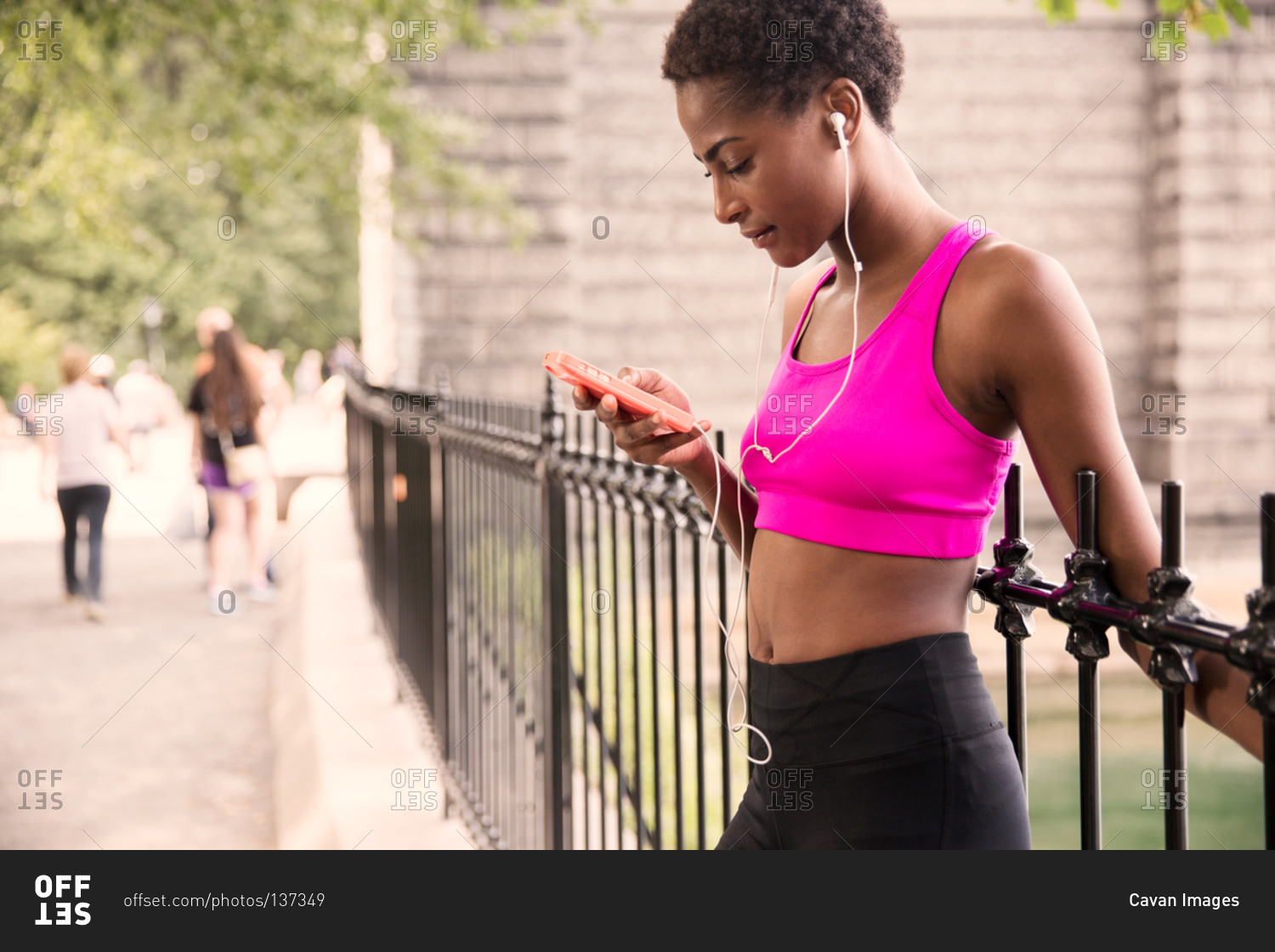 Jogger checking mp3 player near the Pump House, Central Park, New York