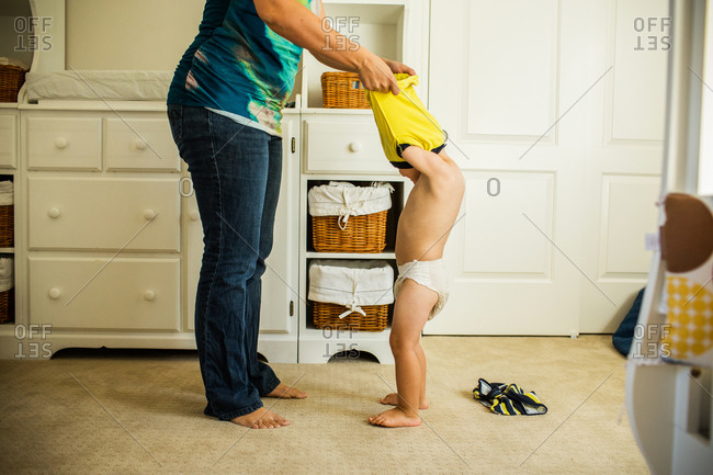 Mother taking off her son's shirt.