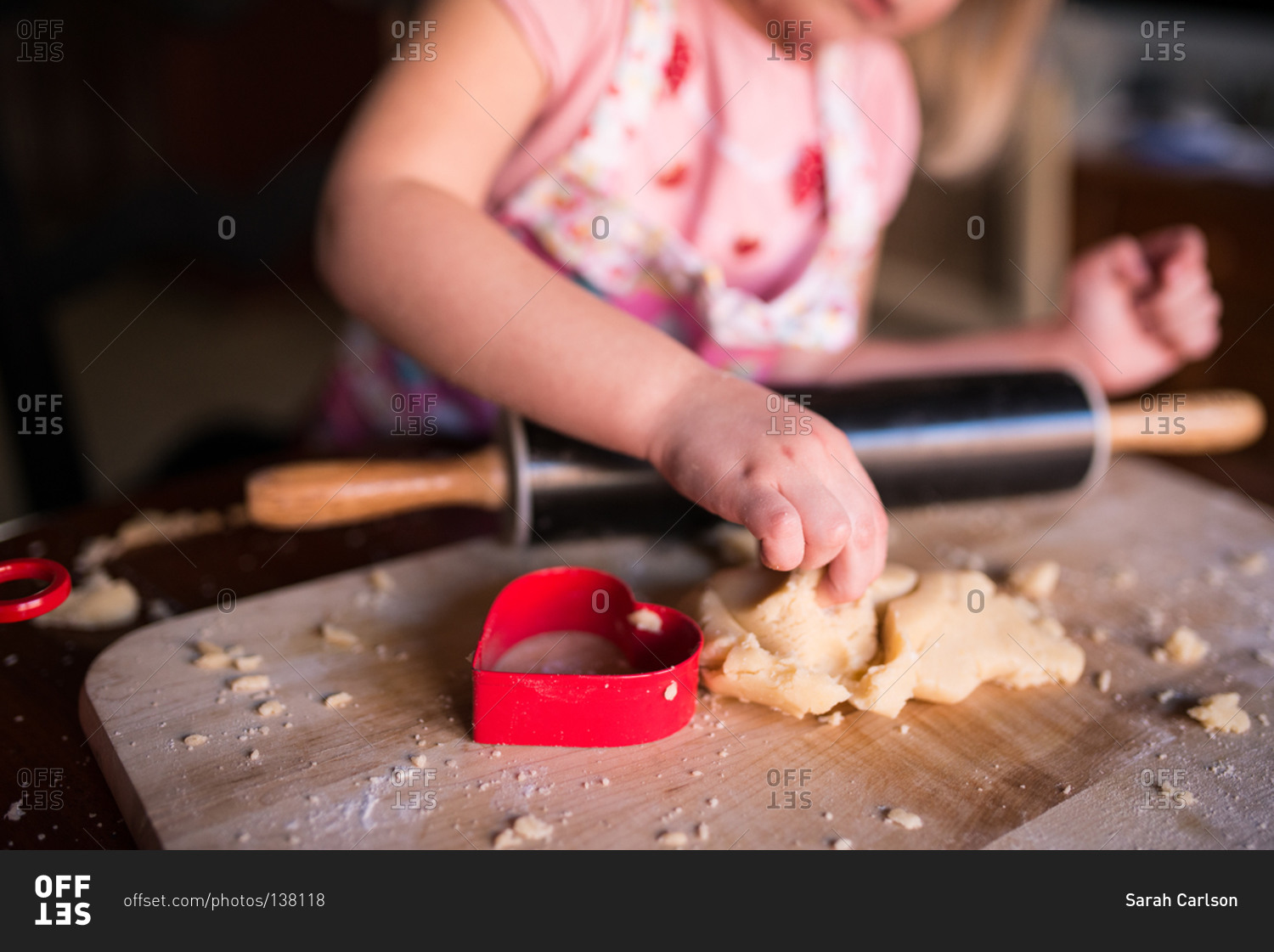Girl making heart-shaped cookies for Valentine's Day