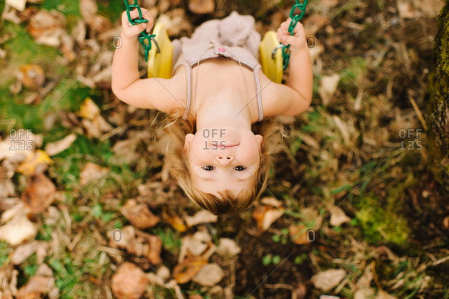 High angle view of girl swinging at the backyard
